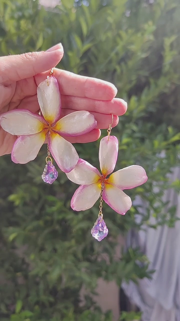 Pendientes artesanales con flores naturales de plumeria tricolor en resina y lágrimas facetadas iridiscente. Joyería botánica única