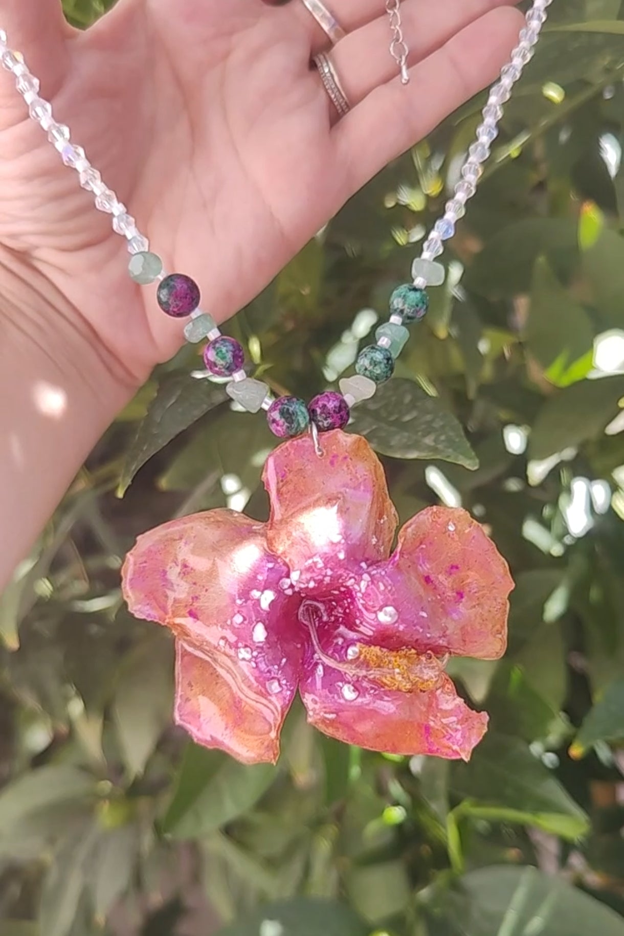Collar de hibisco naranja rosado real resinado, con cristal facetado y piedra mineral natural en  – joya botánica artesana