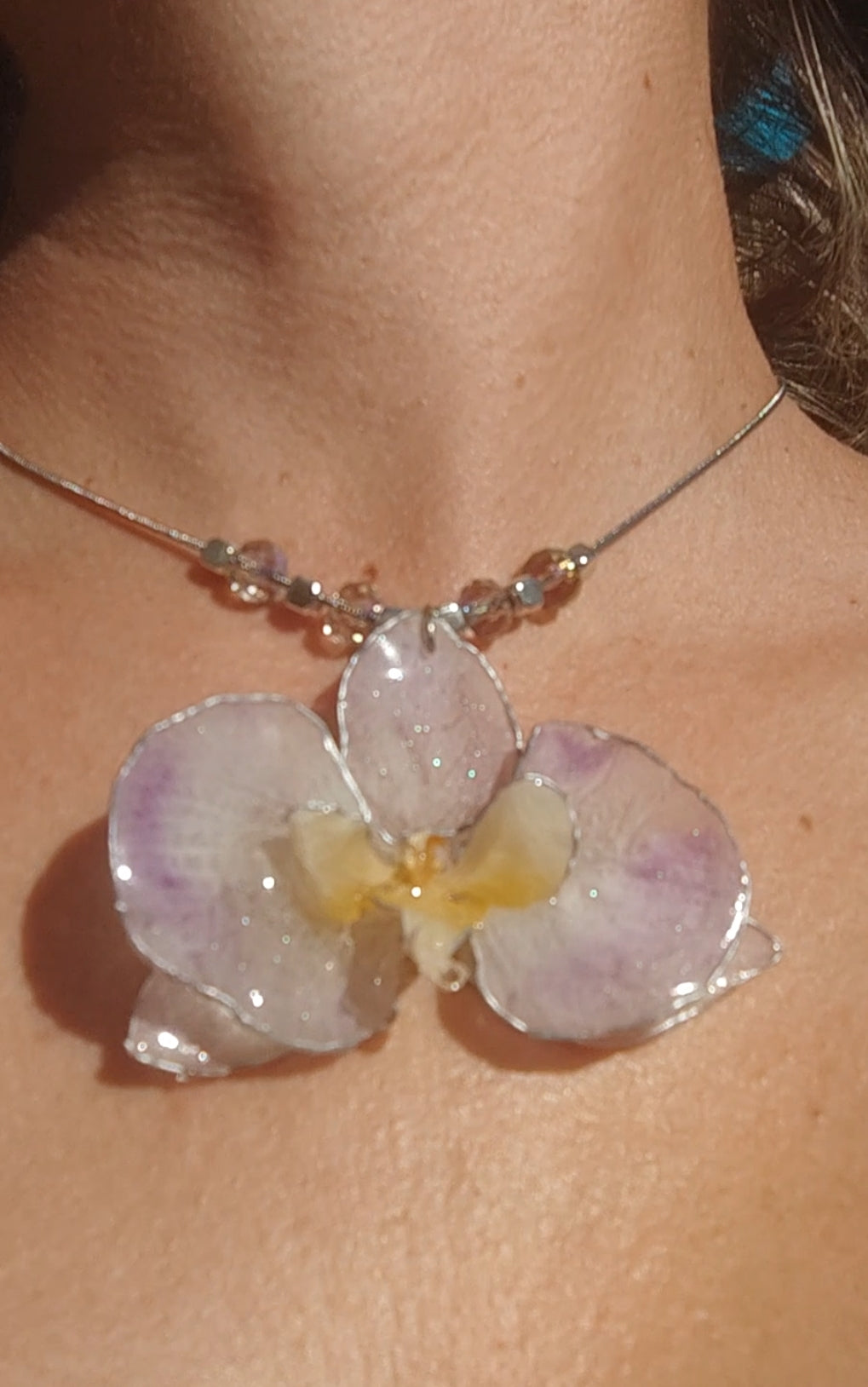 Collar de acero inoxidable hecho a mano con orquídea Phalaenopsis real deshidratada, bordes en nácar lila, resina UV y cuentas de cristal checo