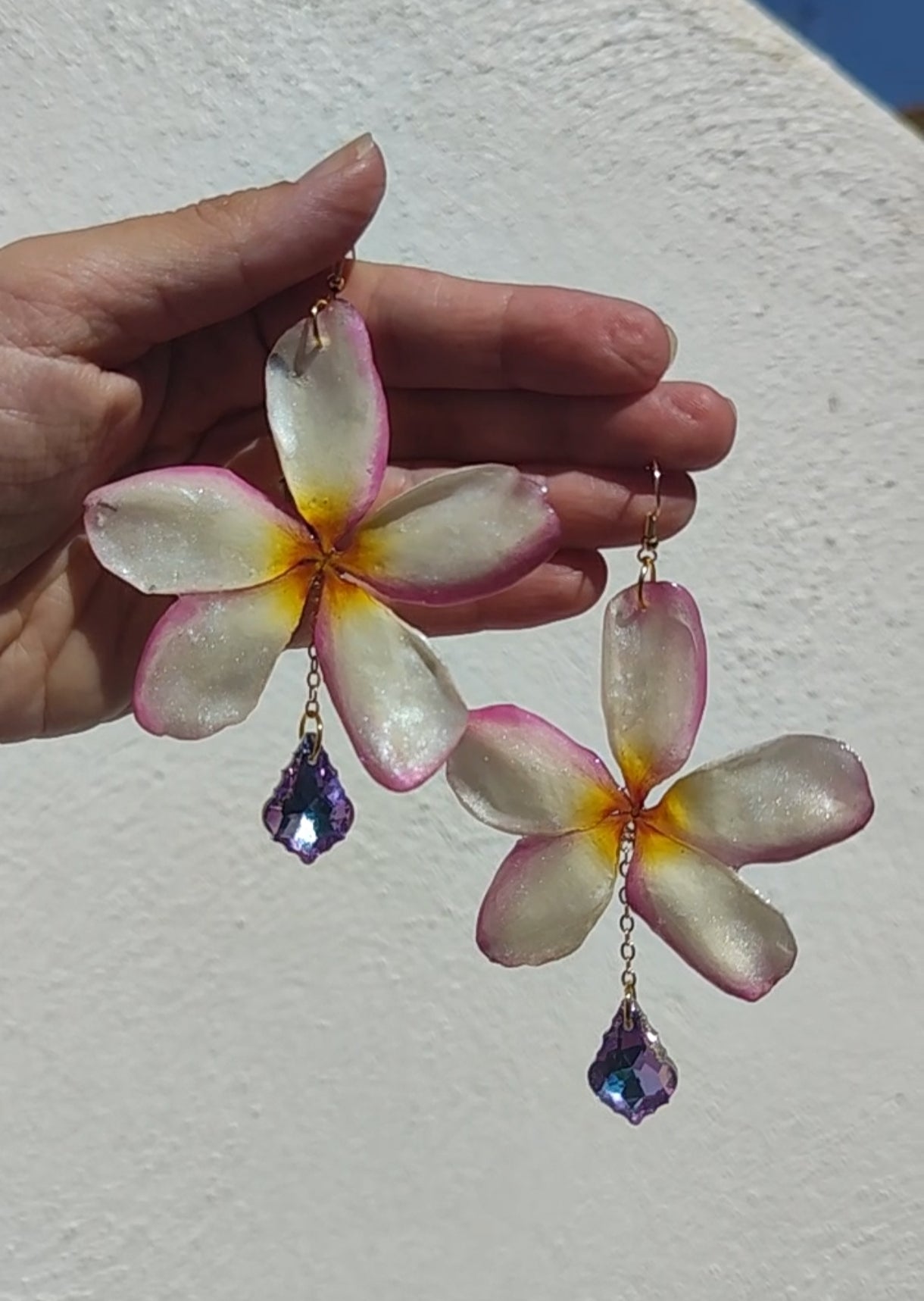 Pendientes artesanales con flores naturales de plumeria tricolor en resina y lágrimas facetadas iridiscente. Joyería botánica única