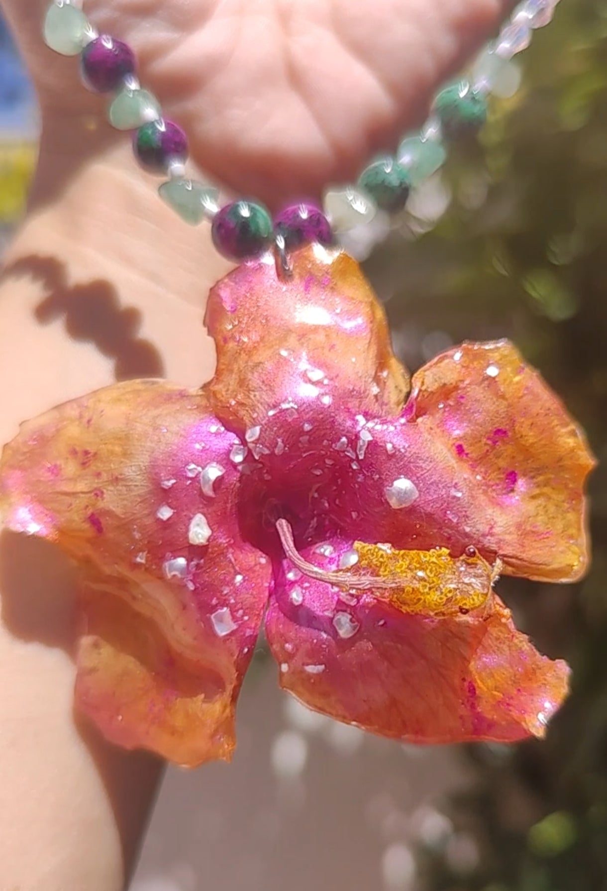 Collar de hibisco naranja rosado real resinado, con cristal facetado y piedra mineral natural en  – joya botánica artesana