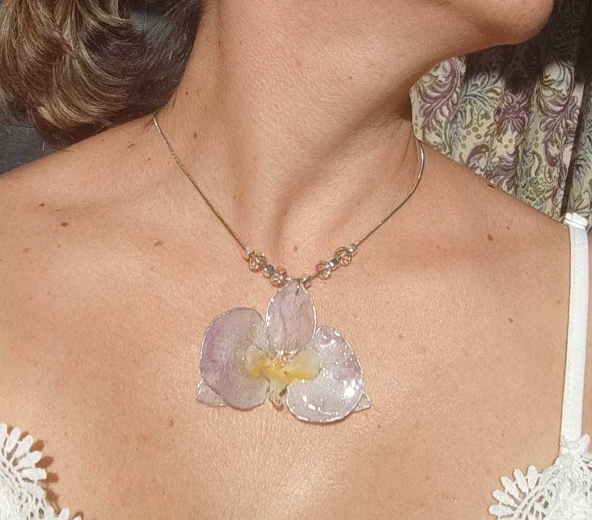 Collar de acero inoxidable hecho a mano con orquídea Phalaenopsis real deshidratada, bordes en nácar lila, resina UV y cuentas de cristal checo