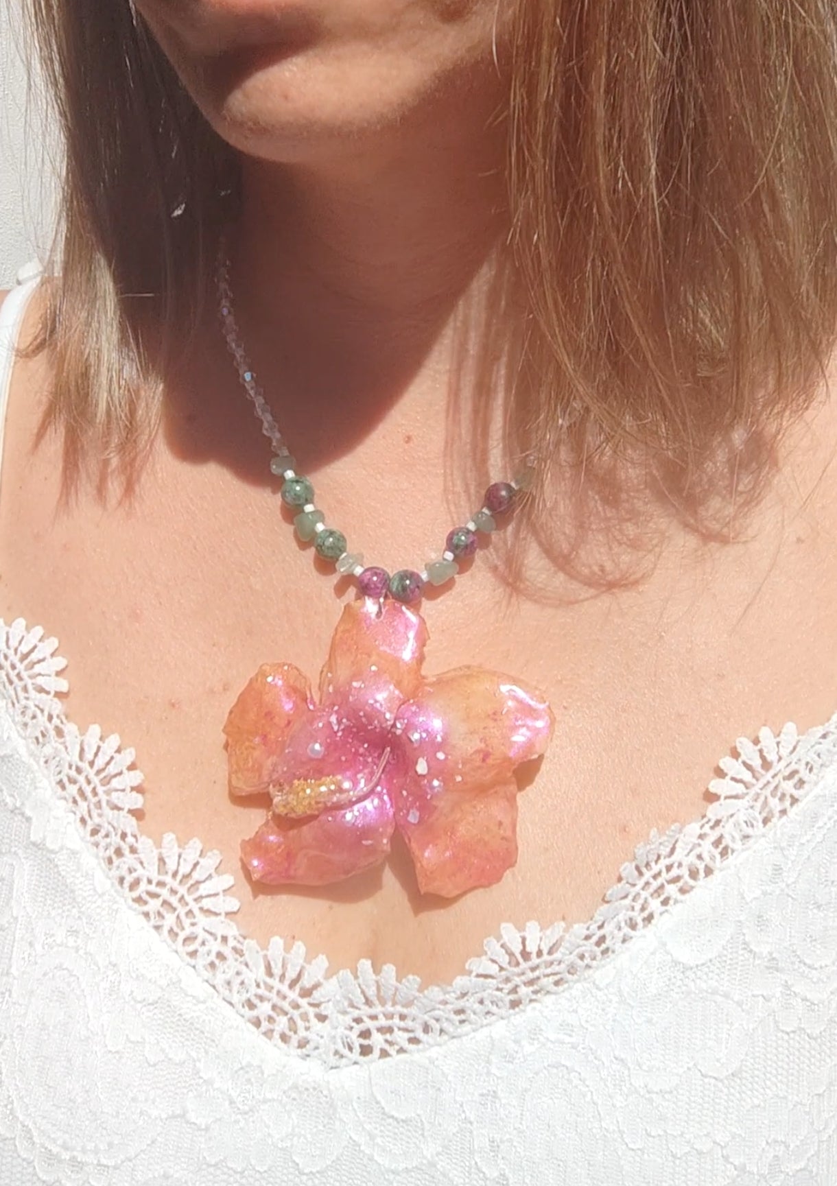 Collar de hibisco naranja rosado real resinado, con cristal facetado y piedra mineral natural en  – joya botánica artesana
