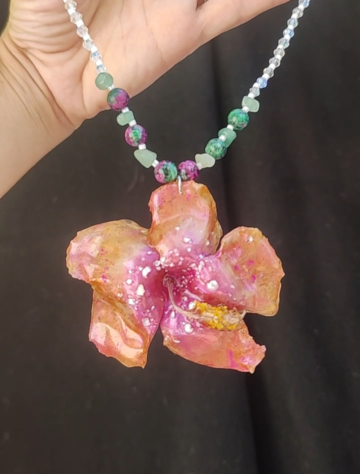 Collar de hibisco naranja rosado real resinado, con cristal facetado y piedra mineral natural en  – joya botánica artesana