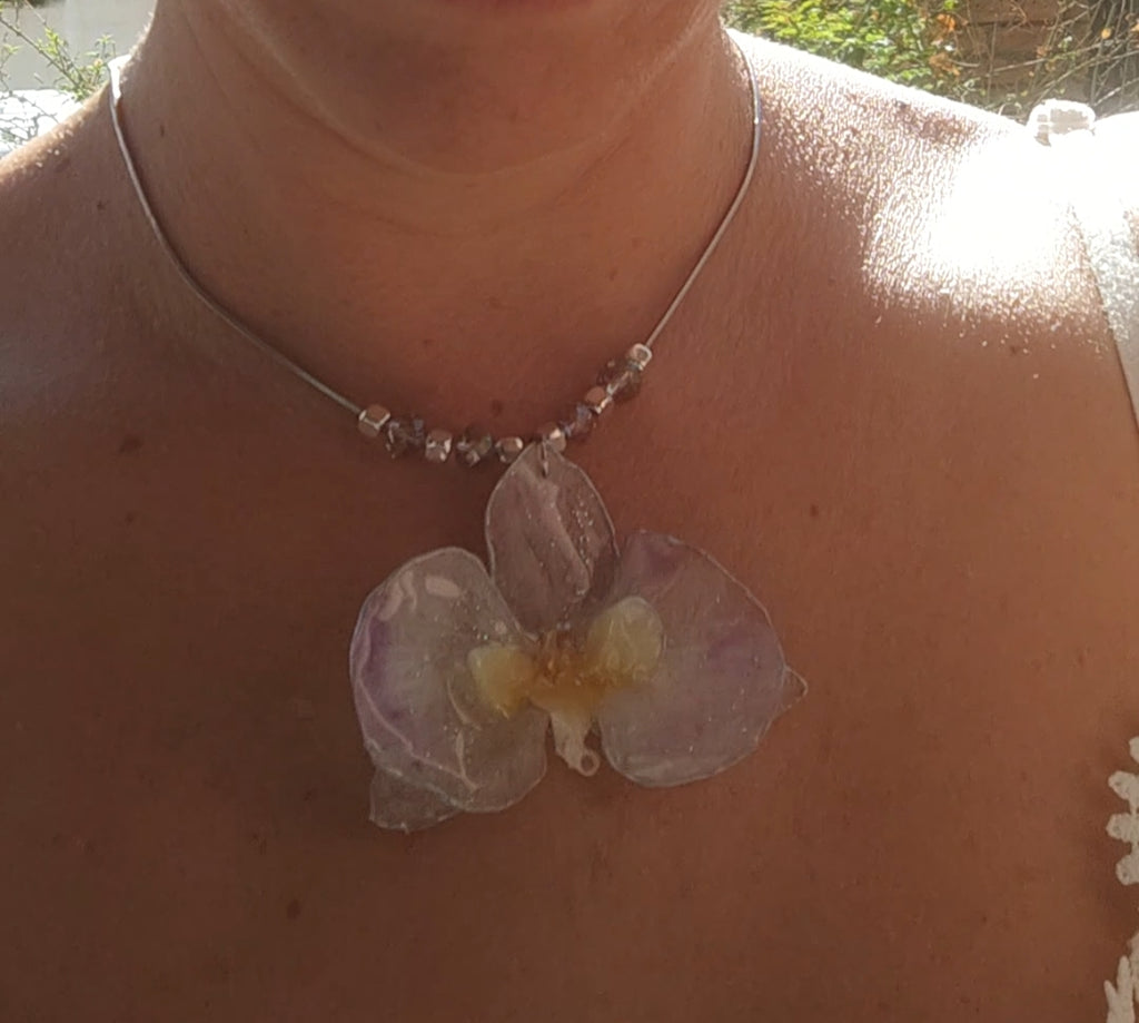 Collar de acero inoxidable hecho a mano con orquídea Phalaenopsis real deshidratada, bordes en nácar lila, resina UV y cuentas de cristal checo