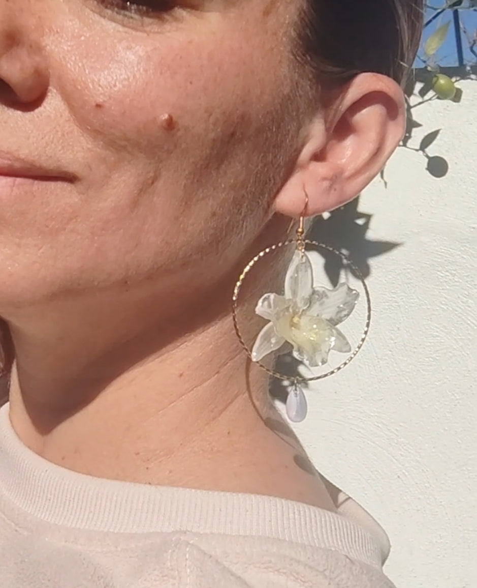 Pendientes con Mini Orquídeas Dendrobium Reales en Resina – Aro Dorado y Lágrimas de Cristal Iridiscente – Joyería Floral Hecha a Mano