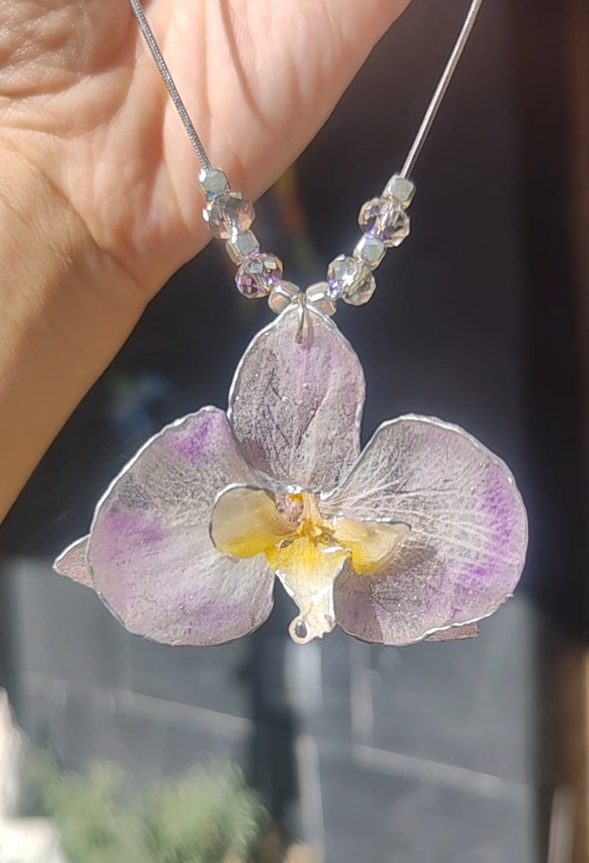 Collar de acero inoxidable hecho a mano con orquídea Phalaenopsis real deshidratada, bordes en nácar lila, resina UV y cuentas de cristal checo