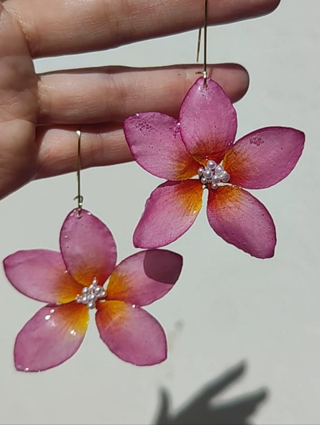 Pendientes flor de plumeria resinada con perlita central. Hechos a mano. Ganchos de acero inoxidable. Joyería floral ligera y elegante