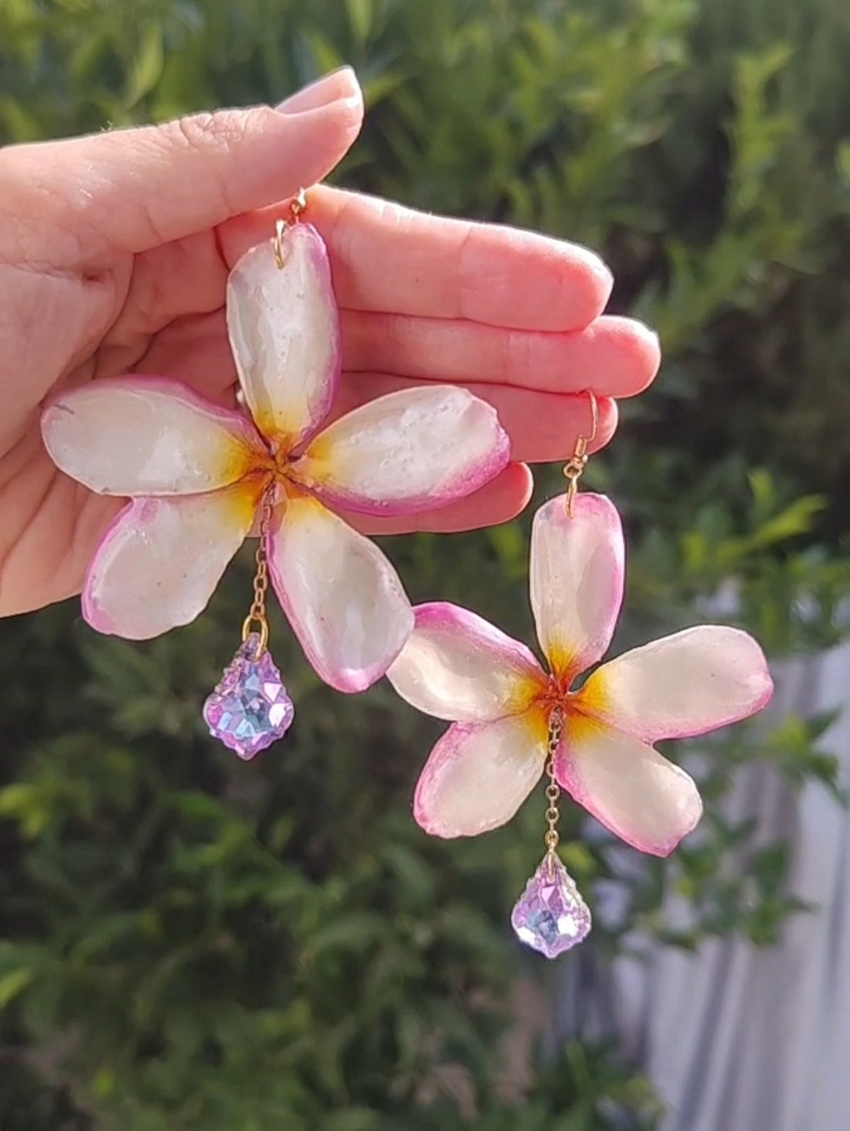 Pendientes artesanales con flores naturales de plumeria tricolor en resina y lágrimas facetadas iridiscente. Joyería botánica única