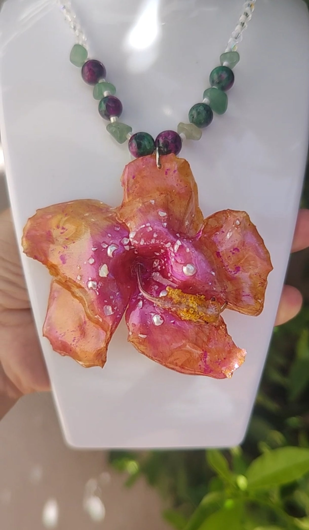 Collar de hibisco naranja rosado real resinado, con cristal facetado y piedra mineral natural en  – joya botánica artesana