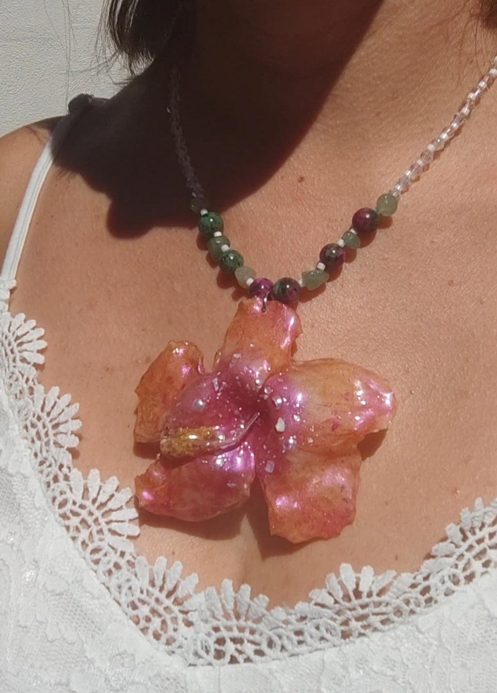 Collar de hibisco naranja rosado real resinado, con cristal facetado y piedra mineral natural en  – joya botánica artesana