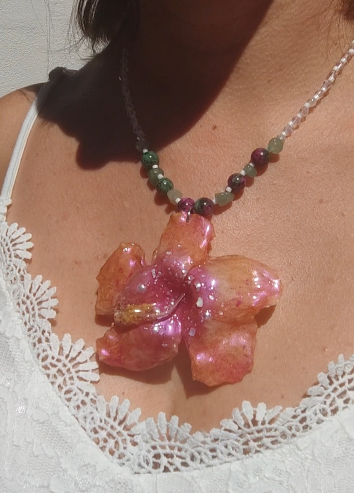 Collar de hibisco naranja rosado real resinado, con cristal facetado y piedra mineral natural en  – joya botánica artesana