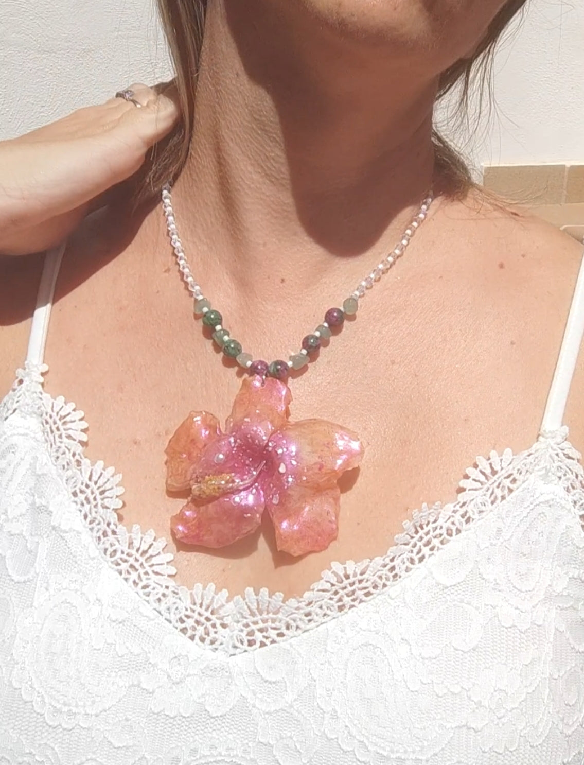 Collar de hibisco naranja rosado real resinado, con cristal facetado y piedra mineral natural en  – joya botánica artesana